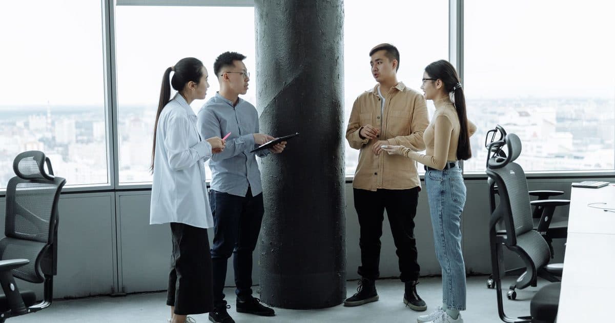 HR team mapping weekly priorities in a standing discussion at a modern office