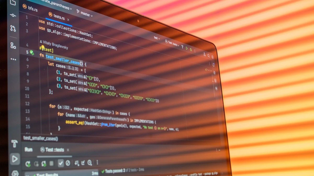 Colorful abstract reflection on screen showing programming code in development environment.