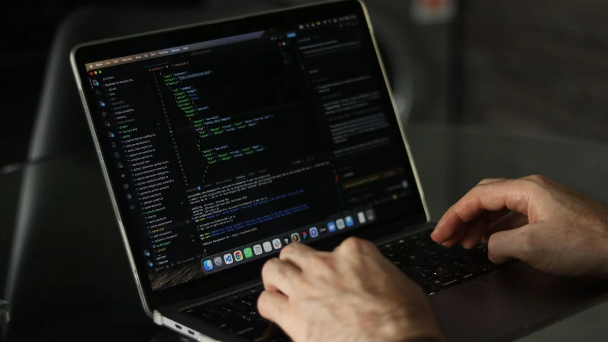 Close-up of hands coding on a laptop, focusing on programming productivity.