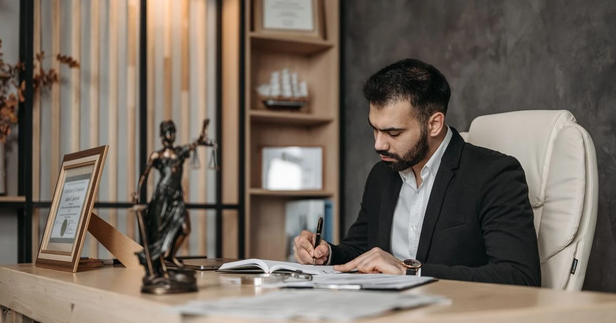 Lawyer reviewing legal documents at a desk in a law office.