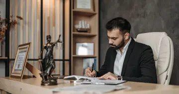 Lawyer reviewing legal documents at a desk in a law office.