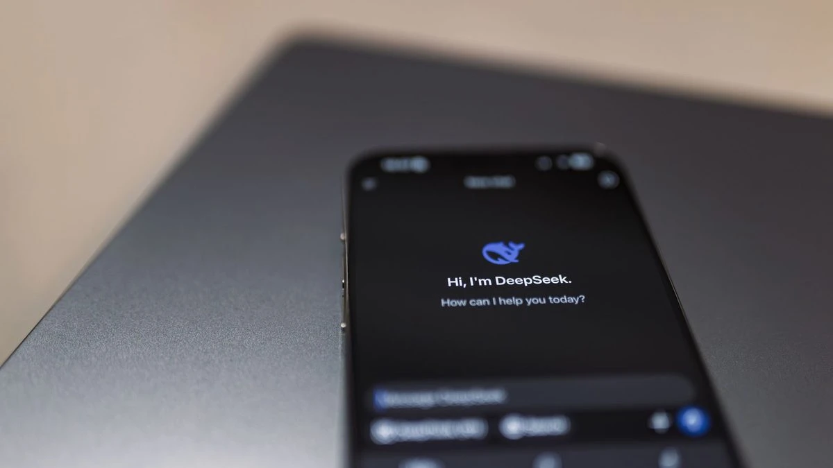 Close-up of a smartphone with AI assistant interface on screen over a laptop.