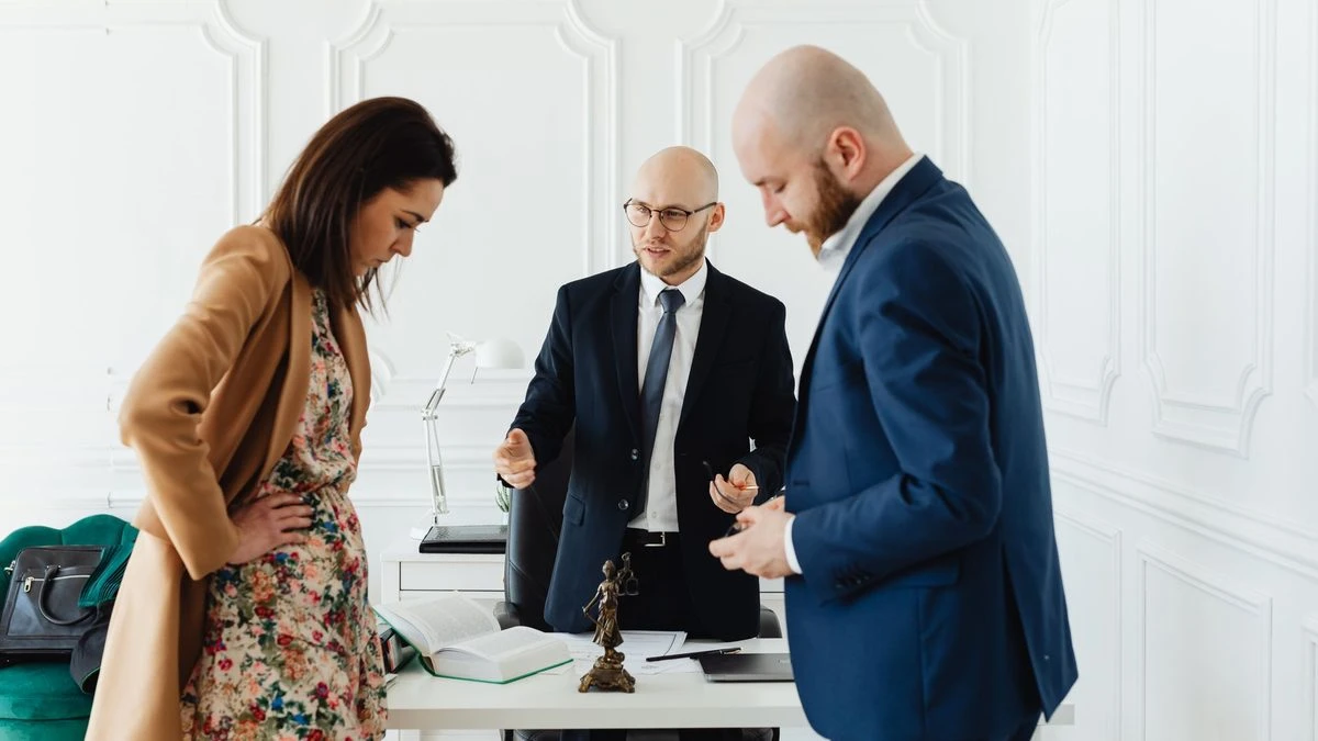 A lawyer meets with clients to discuss legal matters in a professional office setting.