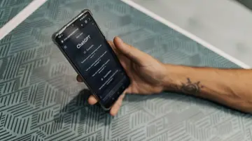 Close-up of a smartphone in hand with ChatGPT on the screen, symbolizing AI technology