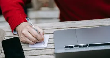 Prompt engineer scoring prompt versions against a test set beside a laptop.