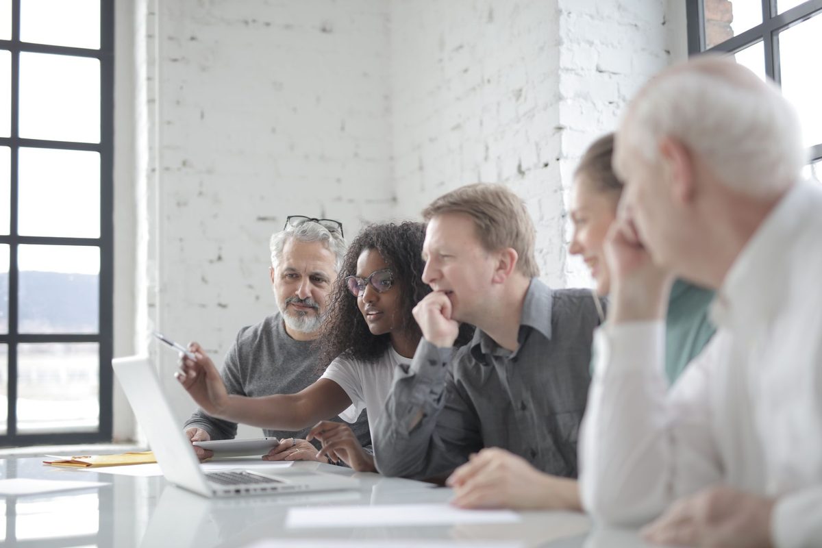 Colleagues reviewing video work together around a laptop